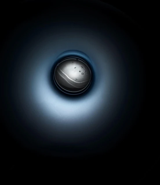 Abstract studio shot of an orb-like water droplet suspended in a dark blue gradient, creating a modern and minimalist visual.