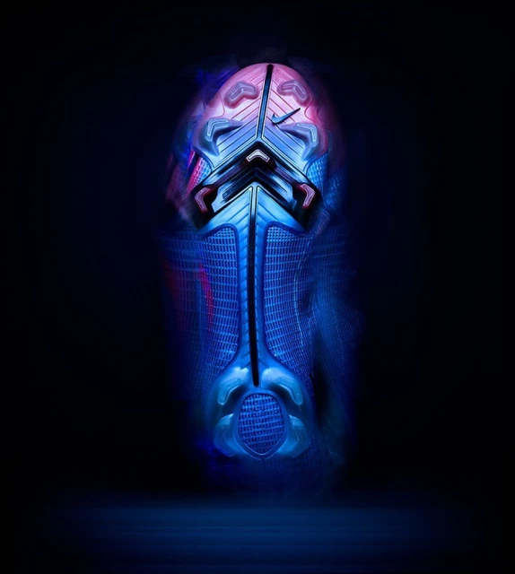 Close-up of a Nike soccer cleat sole, emphasizing its design, textures, and coloration under a dark, atmospheric light.