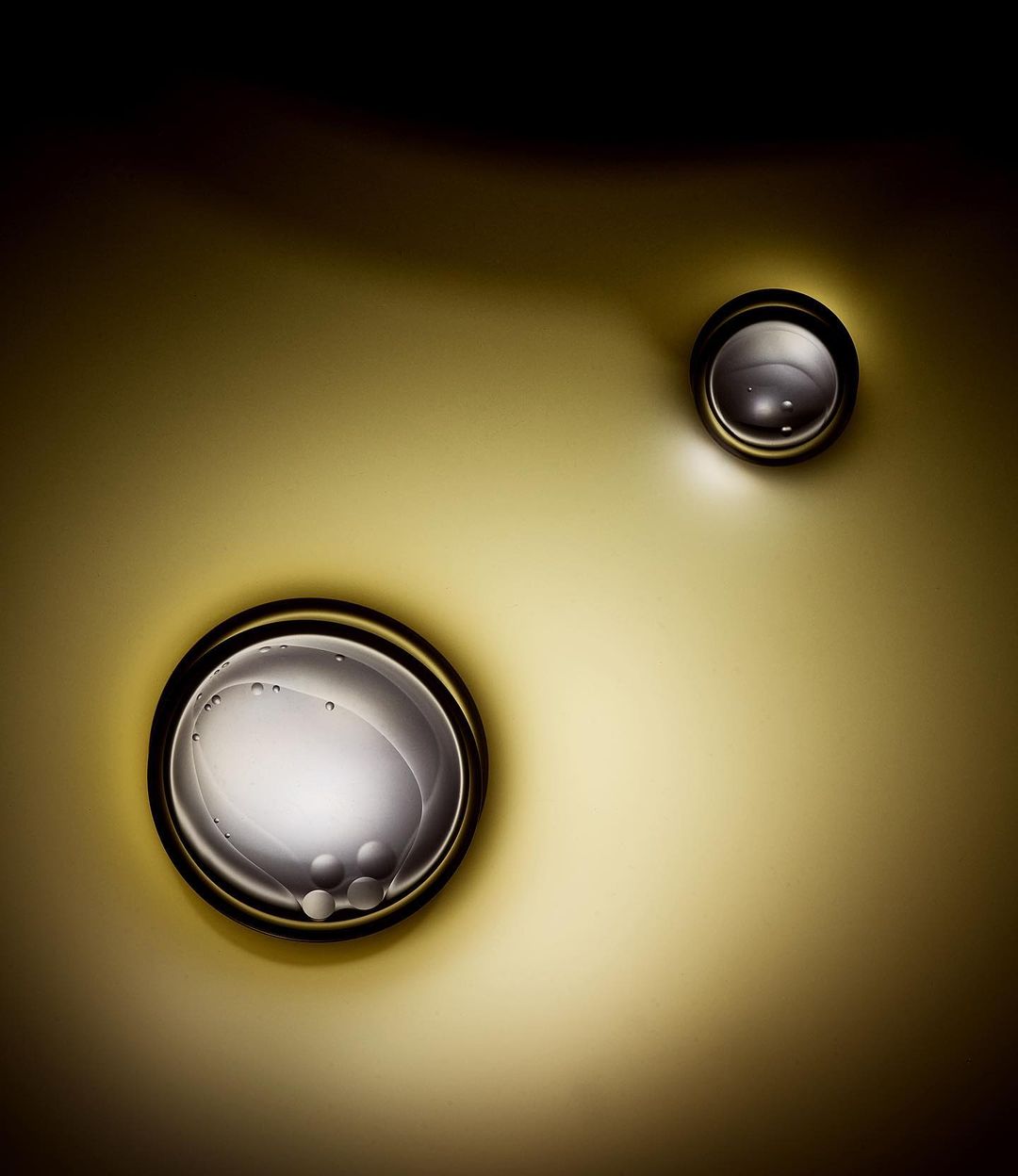 Macro photograph of water droplets on a golden surface, capturing the intricate details of light reflection and surface tension in still life.