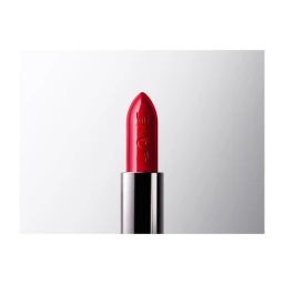 Close-up of a vibrant red lipstick with embossed letters in a silver metal case against a gradient white background.