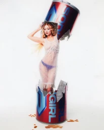 Gigi Hadid emerging from a crushed giant soda can wearing a sheer white dress and blue patterned underwear.