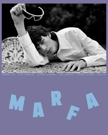 Black and white fashion shot of a young male model with sunglasses on a table, posing outdoors in a patterned shirt, with text overlay.
