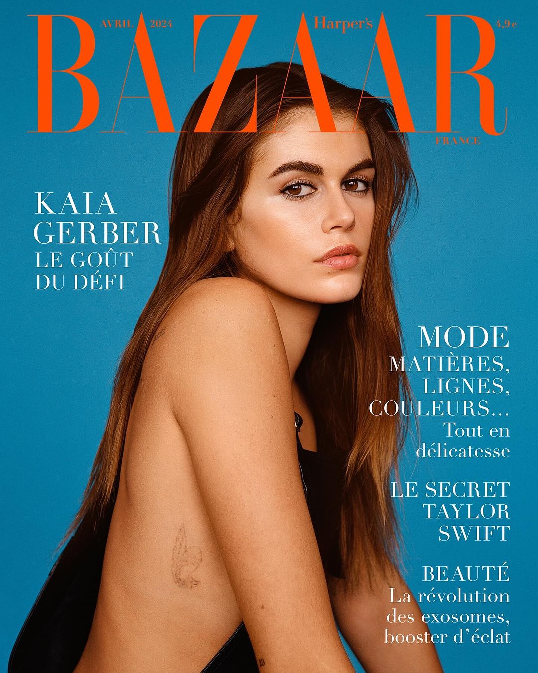 Harper's Bazaar cover featuring Kaia Gerber against a blue background. Editorial fashion photography showcasing minimalist style.