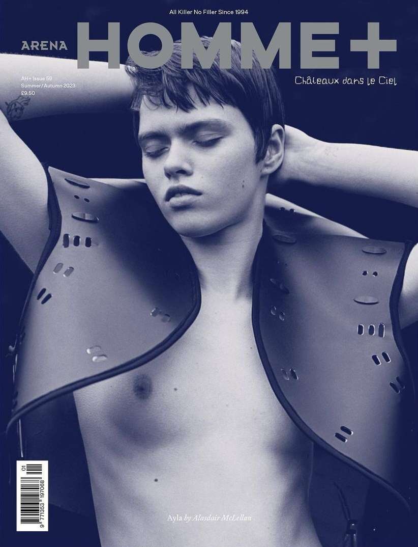 Magazine cover of Arena Homme+ featuring a young adult male model with eyes closed wearing a decorative leather vest and graphic design.