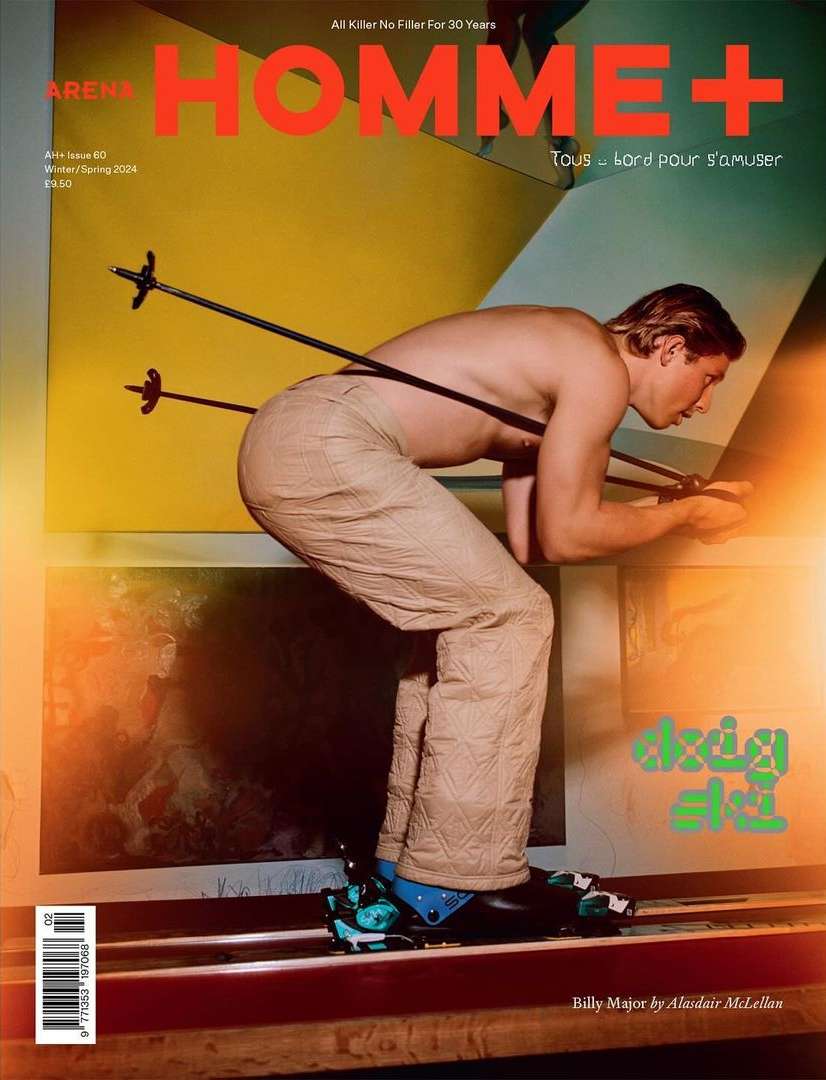 Arena Homme+ magazine cover featuring a shirtless adult male with ski poles across his back, wearing quilted pants and ski boots.