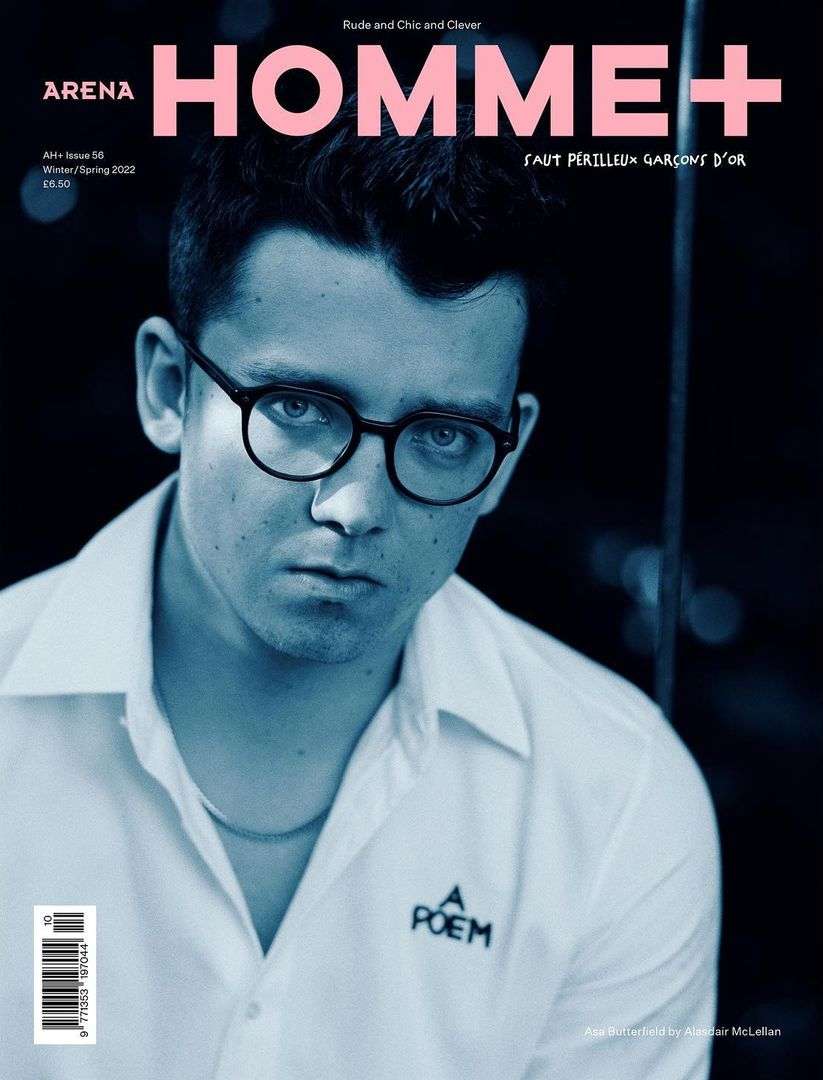 Magazine cover featuring a portrait of a young man with glasses wearing a white collared shirt against a blurred dark background.