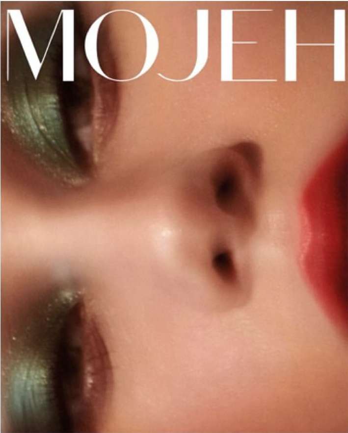 Close-up studio shot of a face with green eyeshadow and red lipstick. The text 'MOJEH' is visible in the upper portion of the frame.