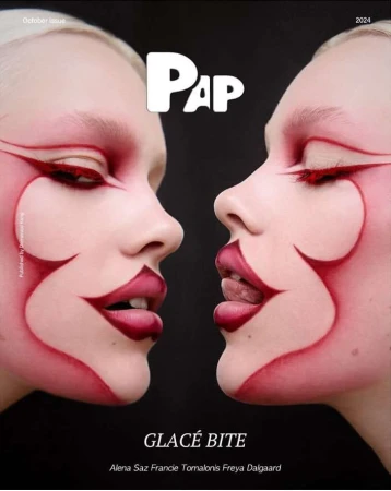 Closeup of two women with pale skin and artistic red eye and face makeup, with red lip makeup in a fashion editorial style.