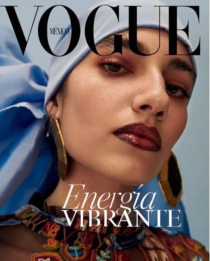 Vogue México cover featuring a close-up of a woman with light skin, wearing a blue headscarf, gold earrings, and a colorful patterned top.