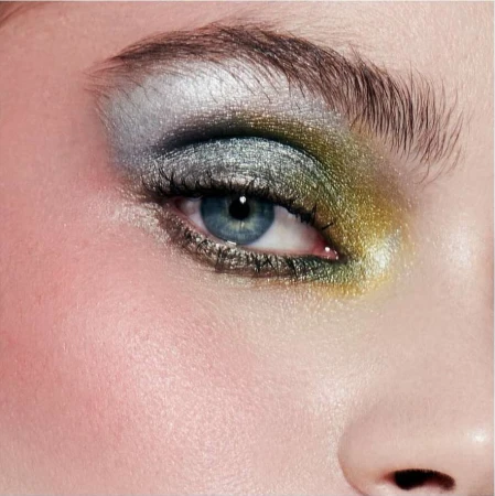 Close-up macro shot of a blue eye with metallic silver and gold eyeshadow and dark eyelashes by photographer Alena Sazonova