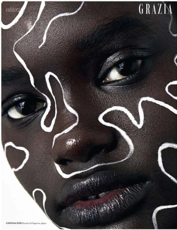 Extreme close-up beauty portrait of a Black woman with abstract white line paint across her face by Alena Sazonova