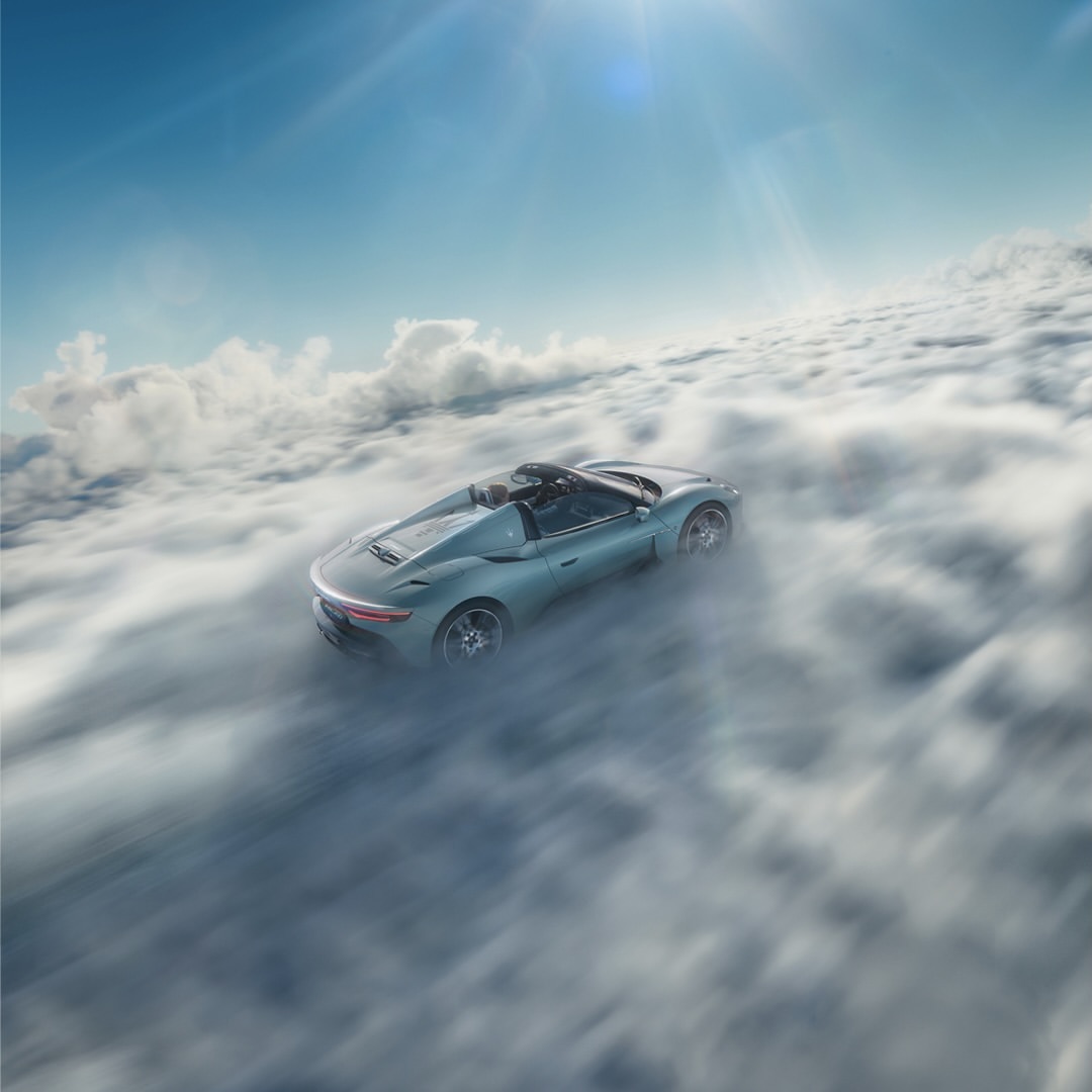 Turquoise convertible car in a sea of clouds against a blue sky, capturing an aspirational, high-altitude automotive dream.