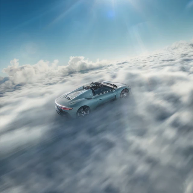 Turquoise convertible car in a sea of clouds against a blue sky, capturing an aspirational, high-altitude automotive dream.