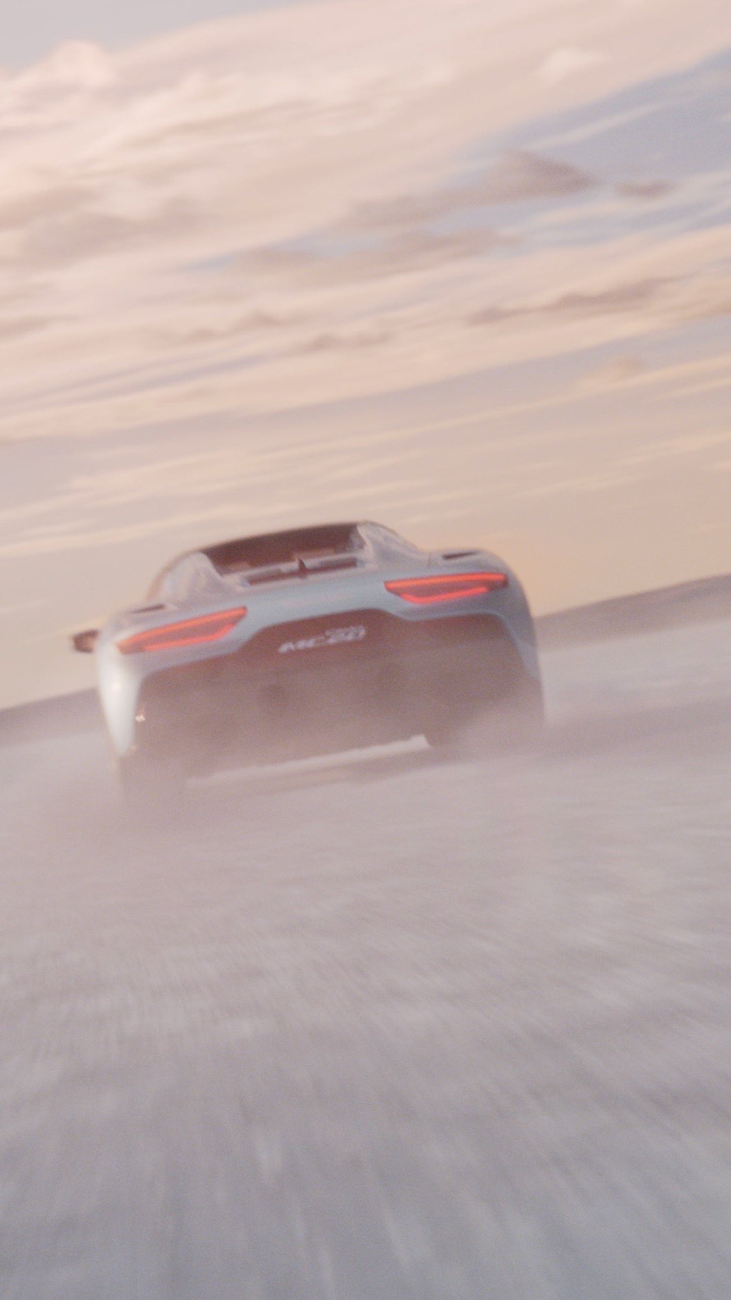 Silver convertible sports car driving on sand dunes at sunset with a blurred motion effect. Vehicle is kicking up dust.