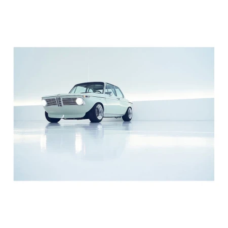 Pale blue vintage BMW car in a bright studio, featuring a glossy floor reflecting the car's sleek design, with a bright backdrop.
