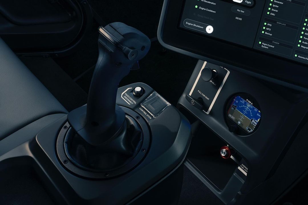 Close-up of the interior of a vehicle cockpit featuring a black control stick, display screen, and instrument panel inside the cockpit.
