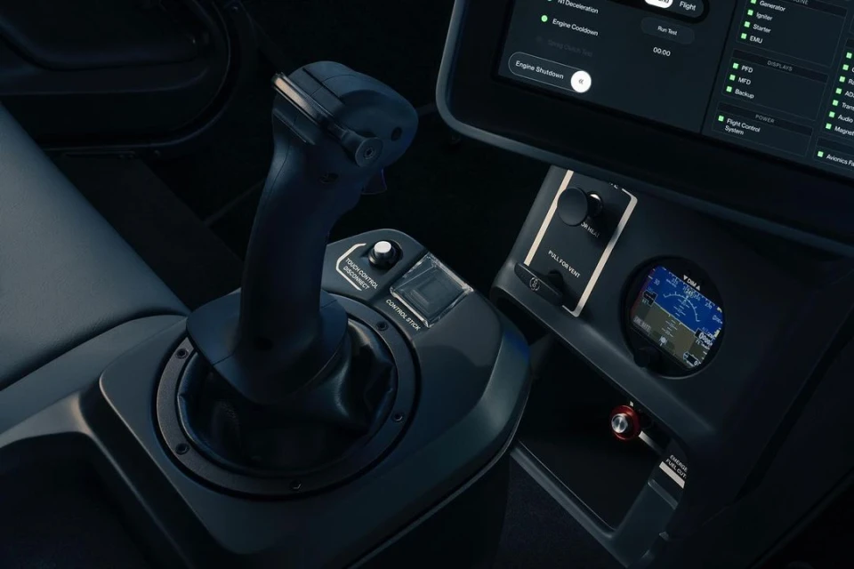 Close-up of the interior of a vehicle cockpit featuring a black control stick, display screen, and instrument panel inside the cockpit.