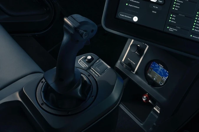 Close-up of the interior of a vehicle cockpit featuring a black control stick, display screen, and instrument panel inside the cockpit.