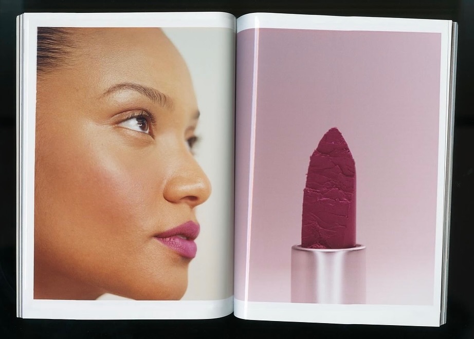 Close-up of a woman's face alongside a lipstick tube in a magazine ad, showcasing makeup and beauty.