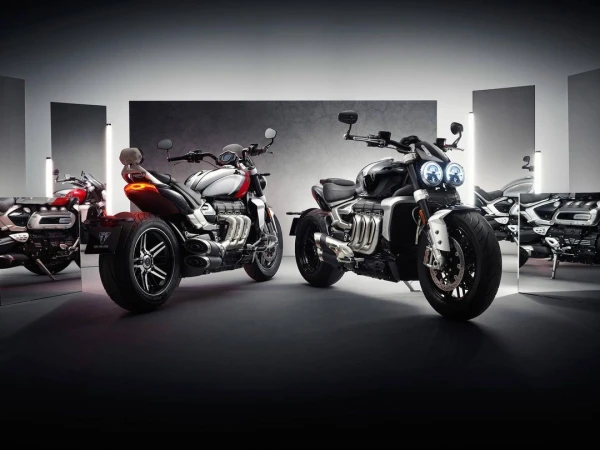Motorcycles aligned for a studio shot featuring sleek design and reflective surfaces, highlighting automotive craftsmanship in a staged setting.