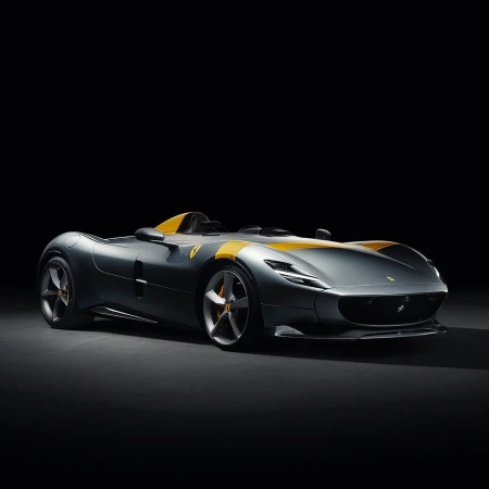 Gray and yellow Ferrari Monza SP1 sports car. Car features aerodynamic design, sleek lines, no windshield and seating for one.