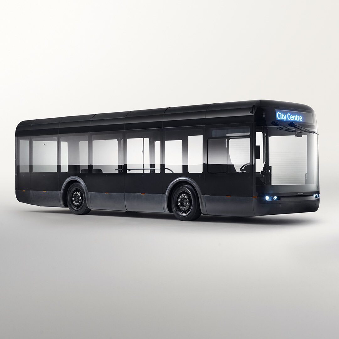 Side view of a dark-colored city bus with visible 'City Centre' sign, set against a bright, neutral studio backdrop, showcasing transportation design.