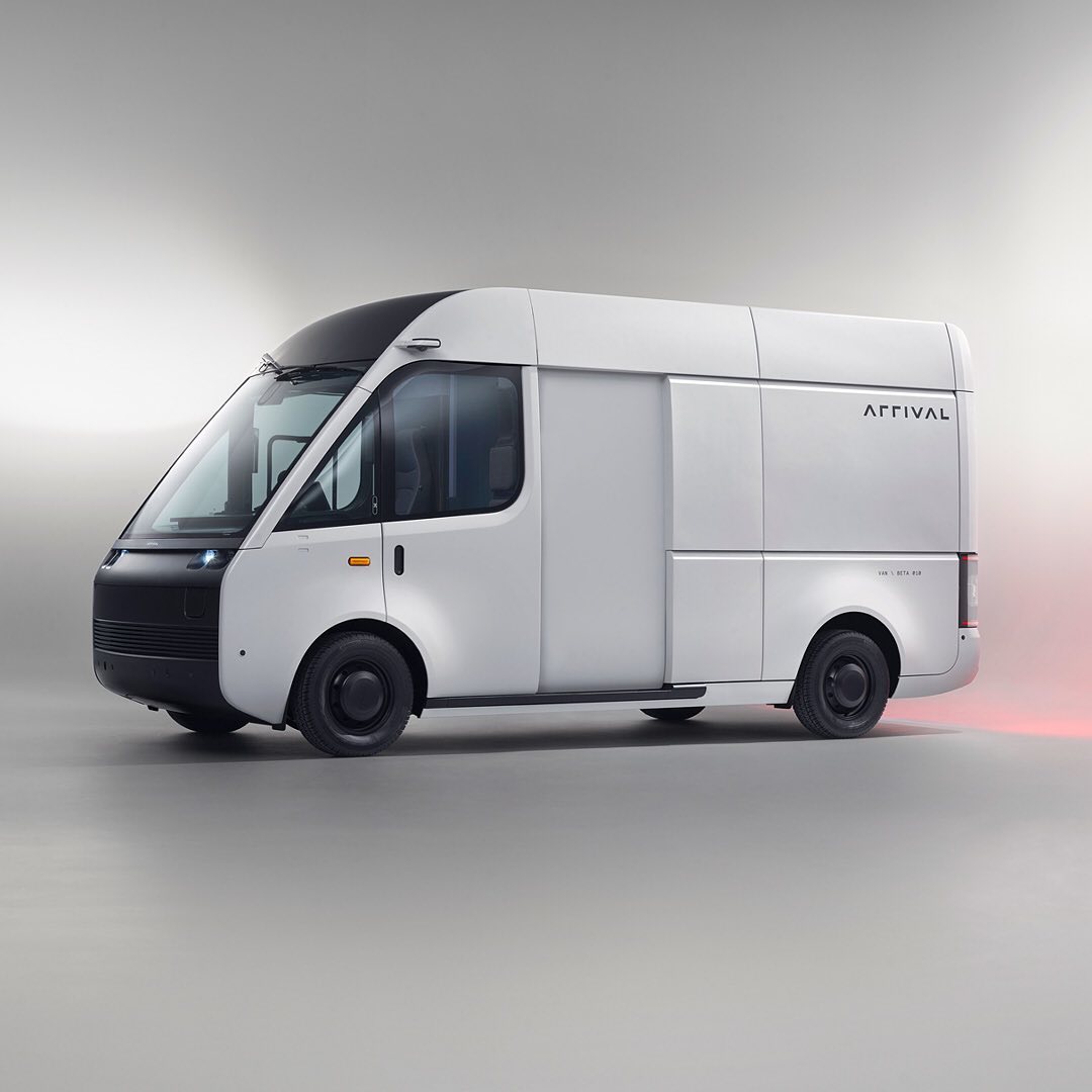 Studio shot of a white Arrival electric delivery van with black tires, set against a plain gray background.