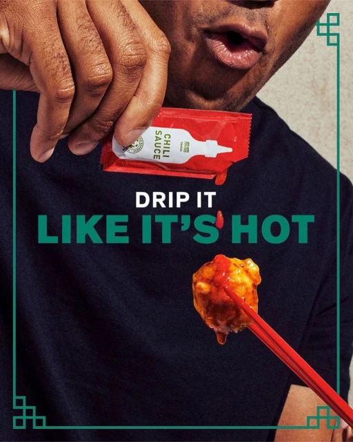 Close-up of a person holding a chili sauce packet and dipping food on chopsticks, with a dark background and text overlay.
