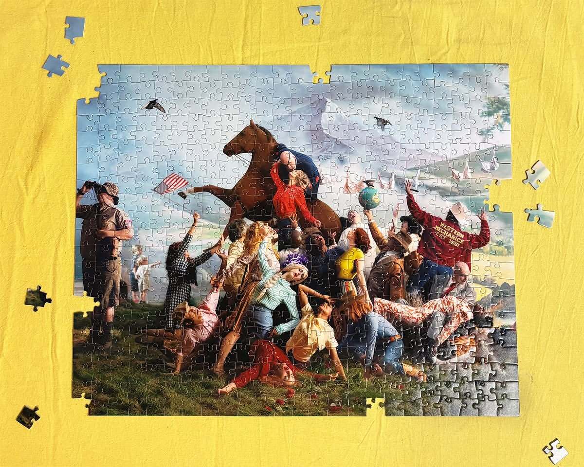 Intricate jigsaw puzzle featuring people, animals, and objects, set against a crumpled yellow fabric backdrop with scattered puzzle pieces.