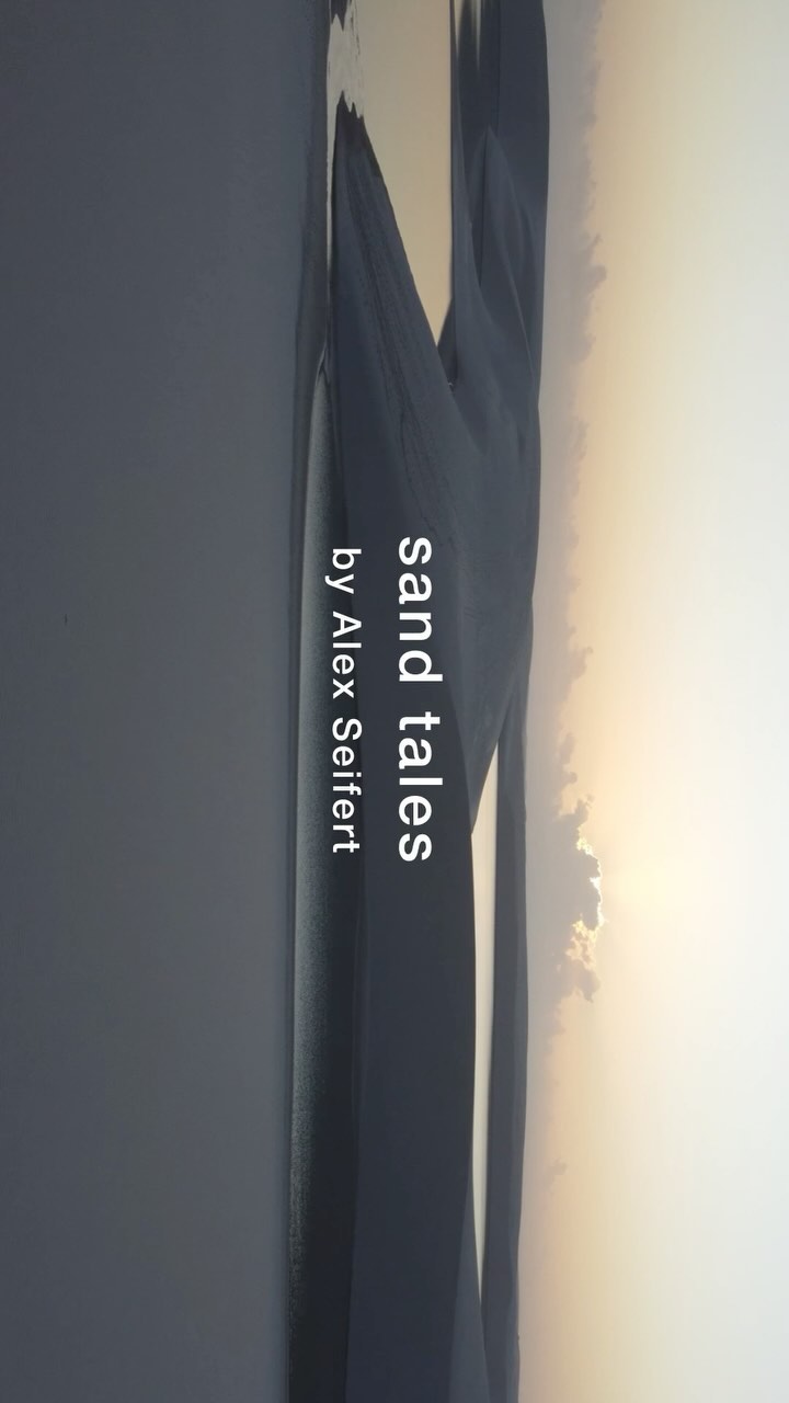 Abstract landscape photograph of a sandy coastline during sunset, featuring soft lighting and hazy colors with visible text overlay.
