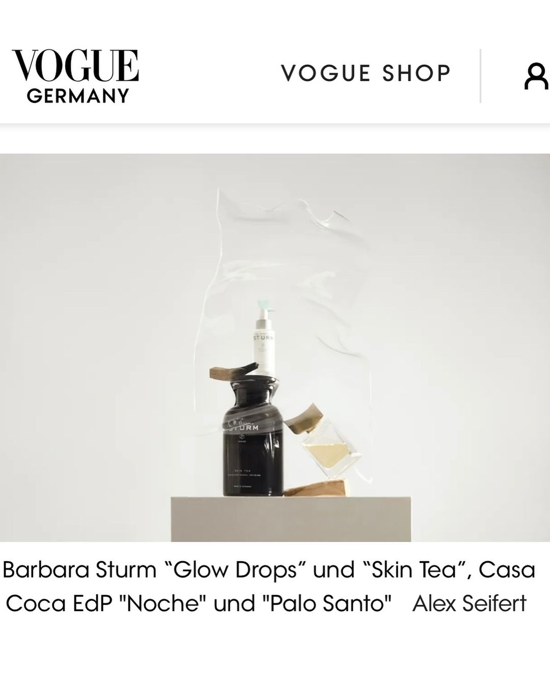 Cosmetic products, including a serum and a bottle of lotion, are displayed on a platform against a white backdrop with "Vogue Germany" text.