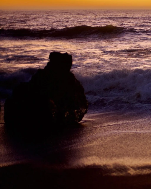 Ocean waves crash on a dark rock at sunset, creating a serene beach scene with an orange and purple sky. The water reflects the light.