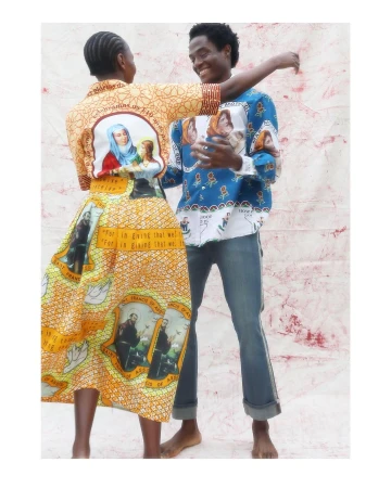 A cheerful couple poses in printed apparel. The man is in blue jeans, while the woman wears a dress and top with a yellow-orange print.