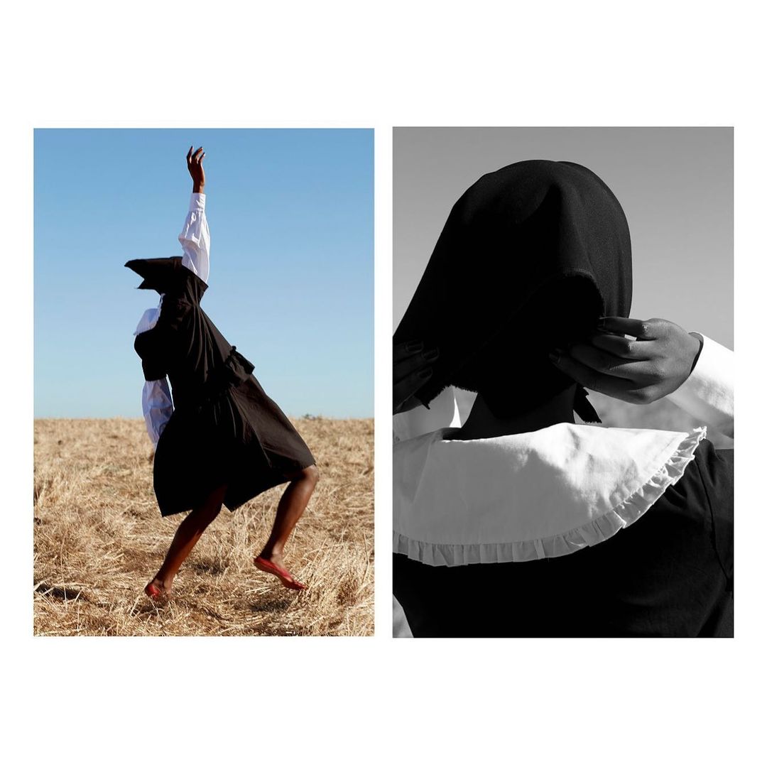 A woman in black dress and white blouse strikes a pose against blue sky and field, monochrome portrait shows her in a head covering.