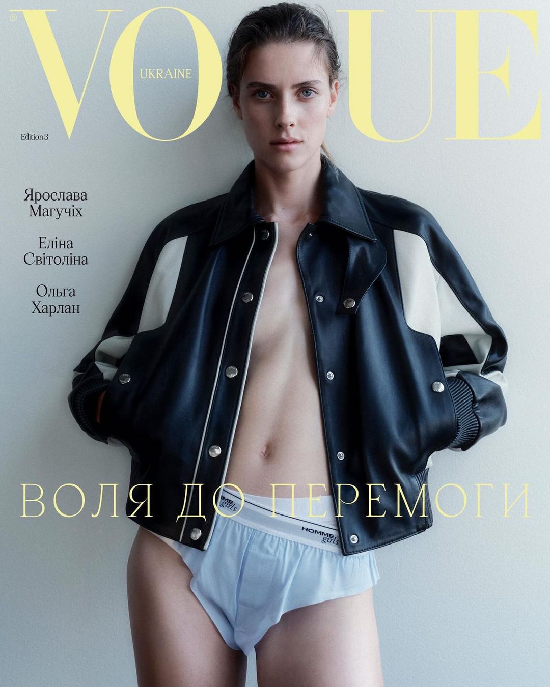 Vogue Ukraine cover featuring a model in a black jacket and light blue underwear against a light gray backdrop. The magazine's masthead is visible.