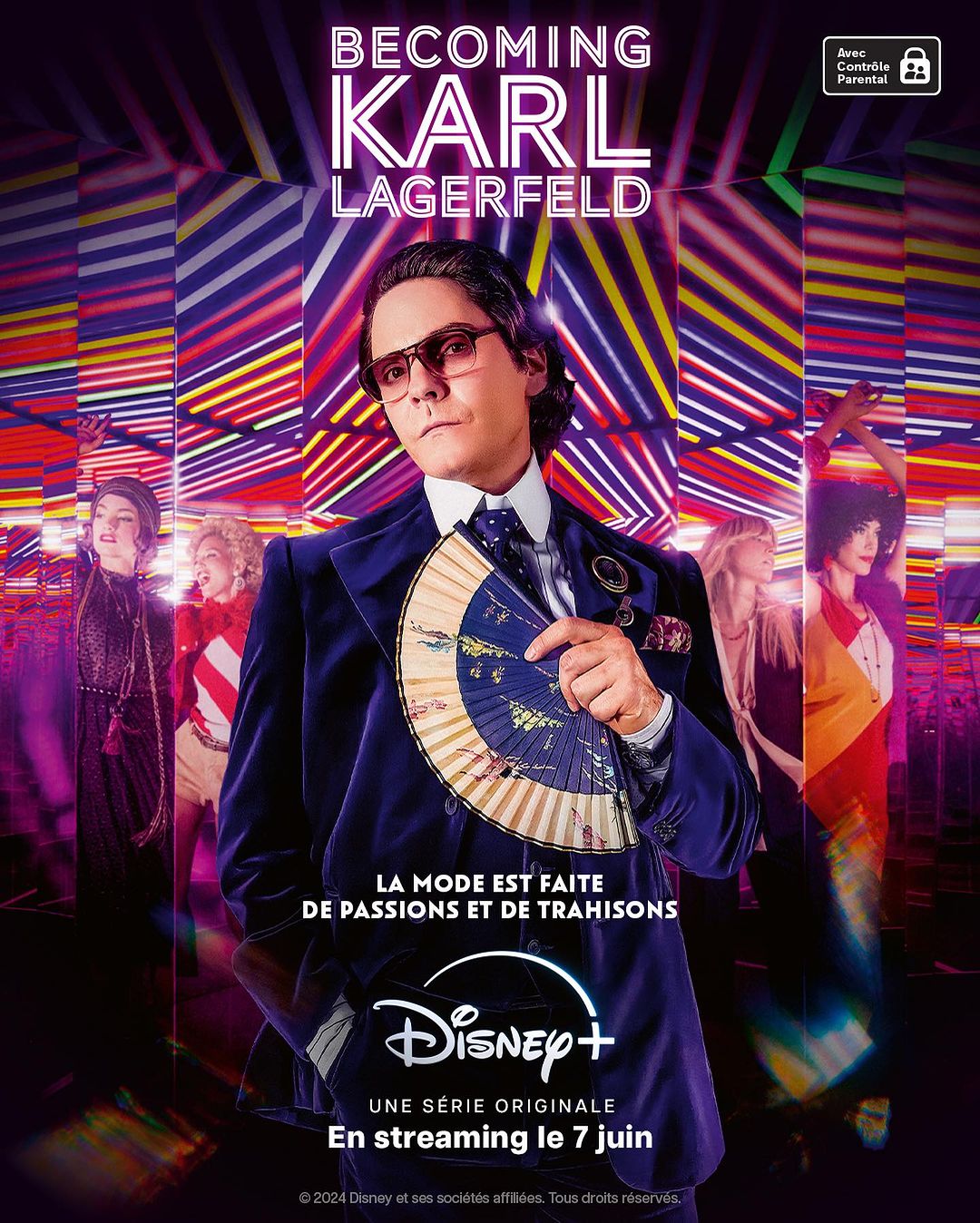 Promotional image for 'Becoming Karl Lagerfeld' on Disney+ features the main actor wearing sunglasses and holding a fan, against a neon backdrop.