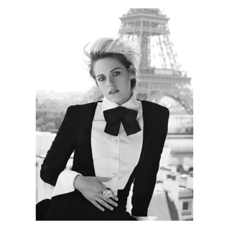 Black and white portrait of a woman with short blonde hair wearing a tuxedo jacket, white shirt, and large bow tie.