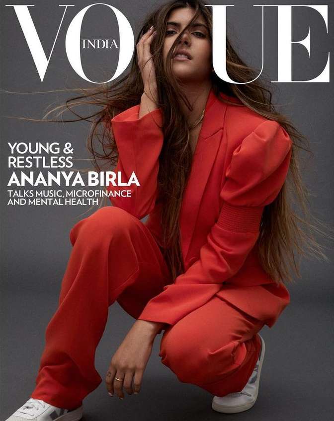 Vogue India cover featuring Ananya Birla in a red suit, crouching in a studio with the magazine's logo prominently displayed.