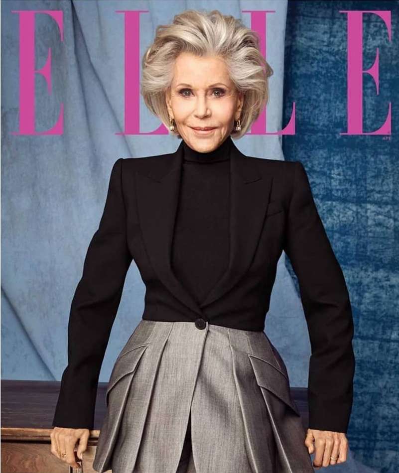 Elderly woman with short, gray hair wearing a black blazer and gray skirt, featured on the cover of ELLE magazine. 