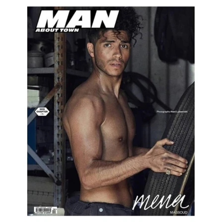 Magazine cover featuring Mena Massoud shirtless, holding tire, with 'Man About Town' title, shot indoors with visible garage-like background.