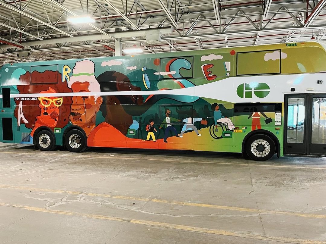 Double-decker bus featuring a vibrant mural with diverse people, promoting inclusivity and community spirit in a bright, colourful setting.