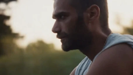 Profile portrait of a bearded man wearing a light blue tank top outdoors during golden hour by Alexis Pazoumian.