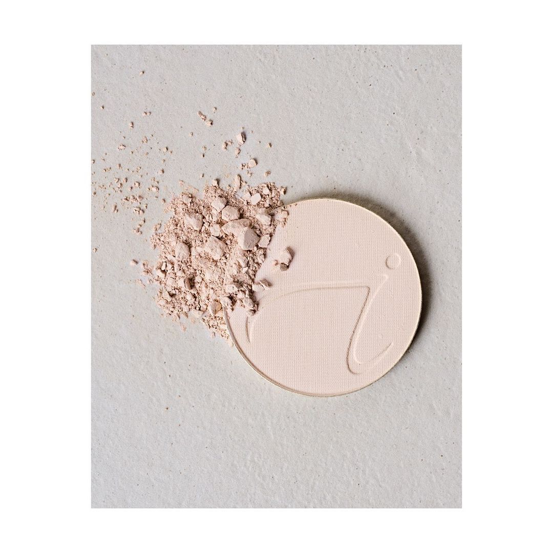 Cosmetic powder product with scattered powder, close-up studio shot on a neutral background. Beauty product for makeup application.