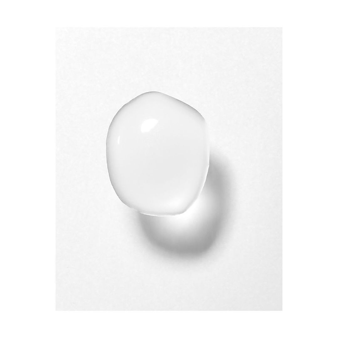Close-up product shot of translucent gel or serum droplet against a stark white background, emphasizing purity and minimalist aesthetic.