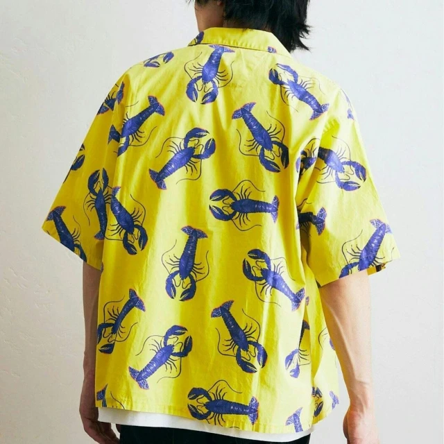 Back view of a person wearing a short-sleeved button-down shirt patterned with repeating blue lobsters against a yellow background.