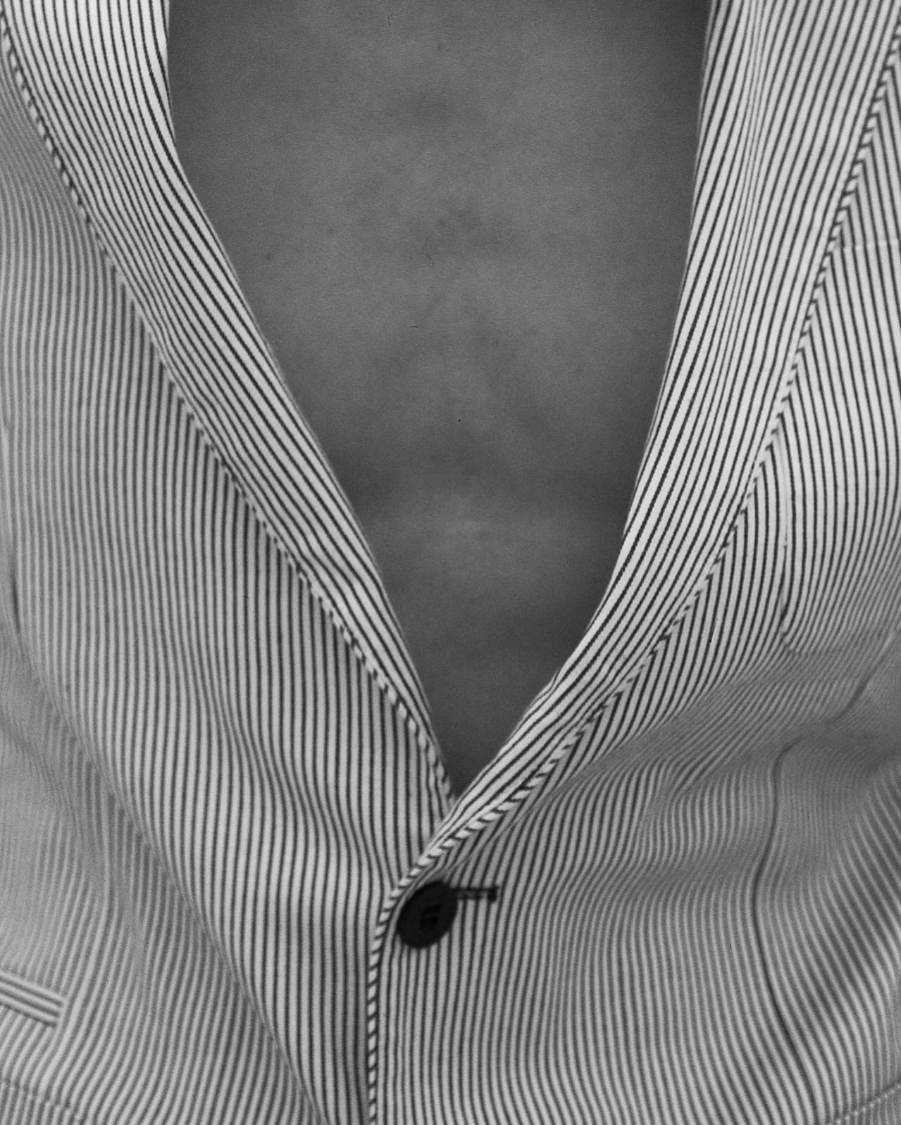 Monochrome close-up of a chest and striped jacket, highlighting texture and depth with sharp focus and contrasting light.
