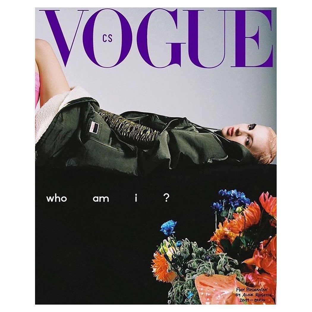 Vogue CS magazine cover featuring a blonde woman in a jacket lying on a dark surface, with text and a flower arrangement.