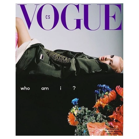 Vogue CS magazine cover featuring a blonde woman in a jacket lying on a dark surface, with text and a flower arrangement.