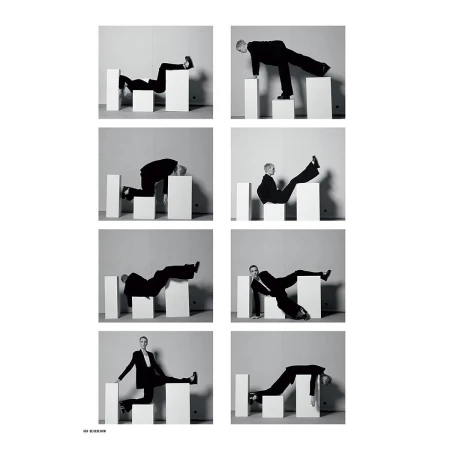 Black and white fashion shot shows woman in black suit posing in eight poses atop white cubic blocks against a plain light gray backdrop.
