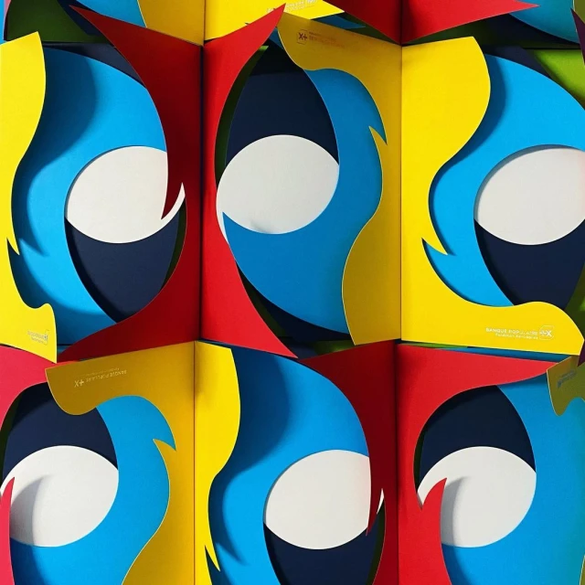 Abstract geometric art with vibrant colors: red, yellow, blue, and white, creating an eye-catching optical illusion pattern.